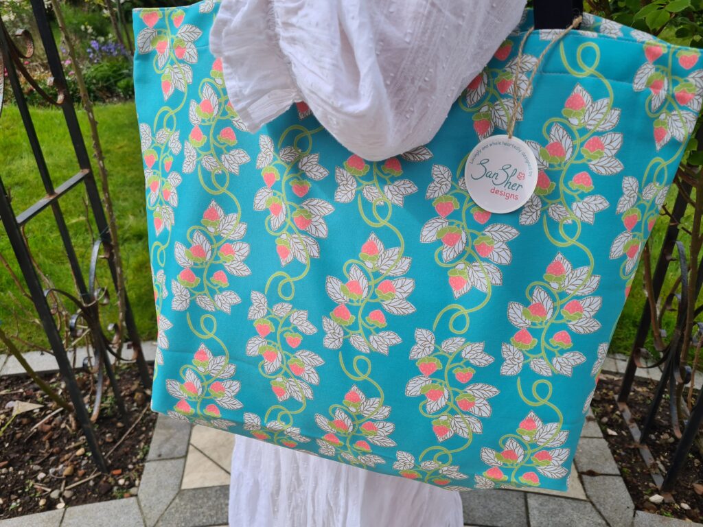 Strawberry vine pattern on a vibrant blue tote bag